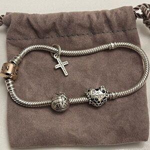 Silver Charm Pandora Bracelet with a Globe, Cross, and (Be Happy) Heart